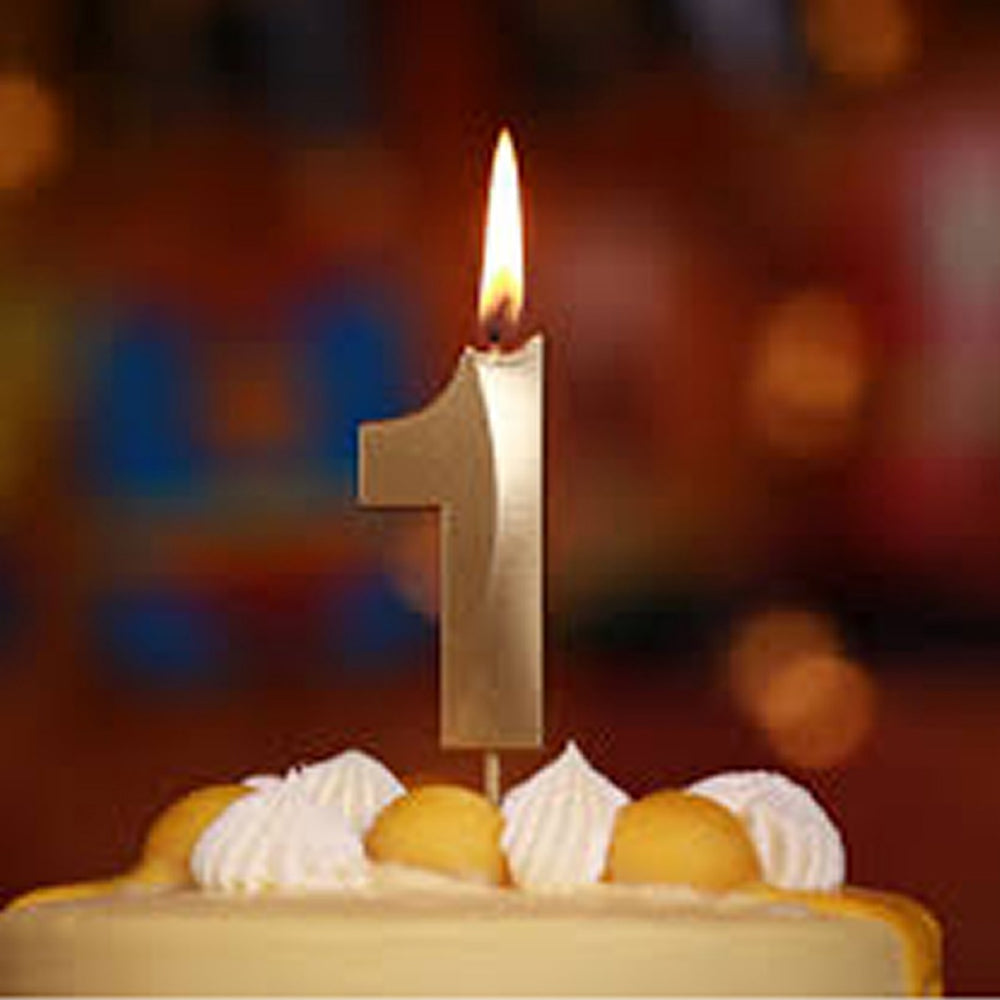 Close-up of Golden Number 0 Candle lit on cake during celebration