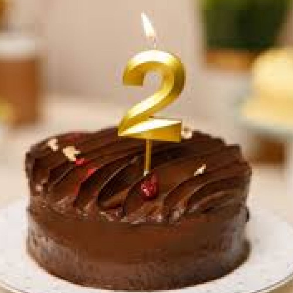Close-up of Golden Number 0 Candle lit on cake during celebration