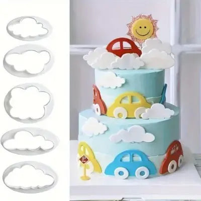 Children's birthday cake with toy cars and clouds, accompanied by cookie cutters shaped like cars and clouds.