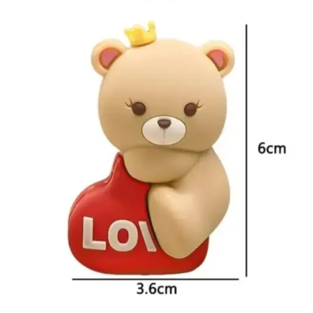 Miniature 6cm x 3.6cm teddy bear cake topper with adorable princess design, wearing a bright yellow crown, hugging a red love heart with embossed white letters, made for decorating anniversary cakes, couple’s bakes, kids’ parties, or themed fondant projects