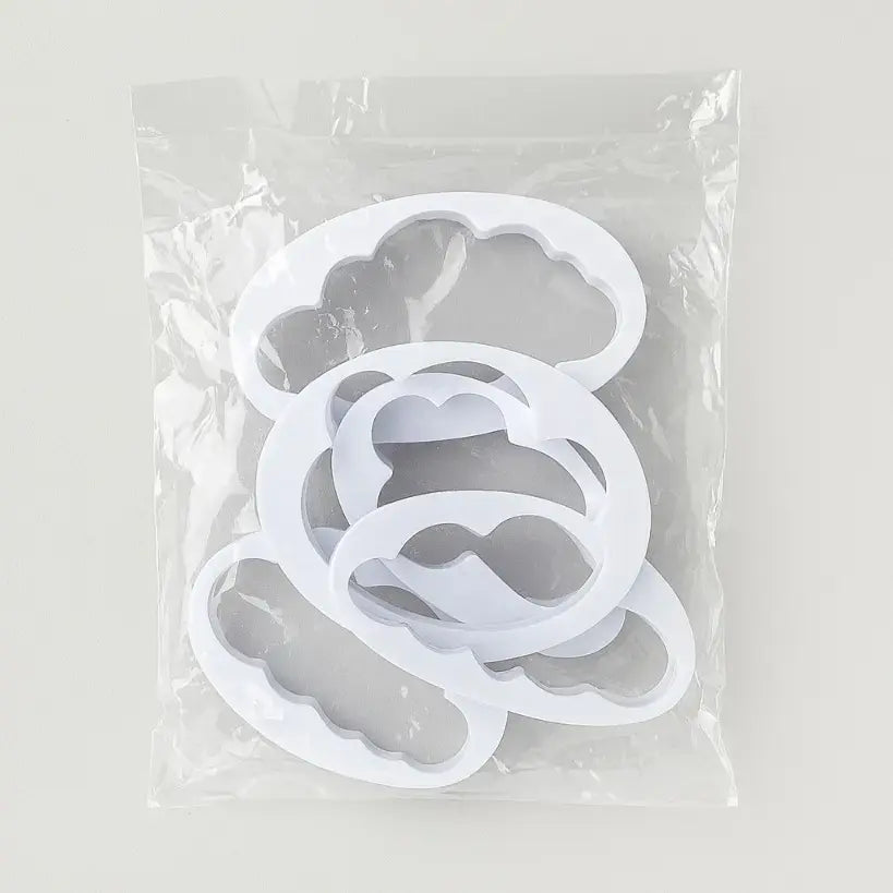 Set of silicone mold shapes in a clear plastic bag on a light gray background