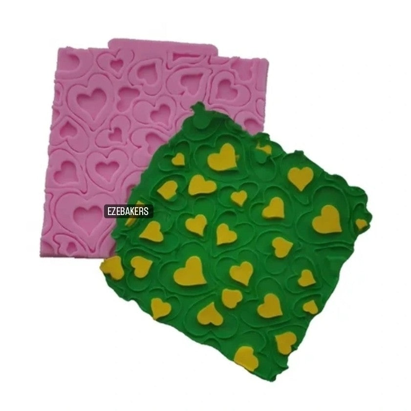Pink and green silicone molds with heart patterns on a white background