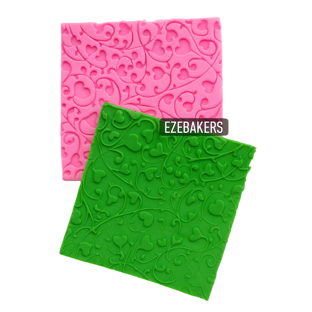 Two silicone molds with intricate patterns, one pink and one green, on a light gray background, with heart design. Brand 'EzeBakers' is visible.