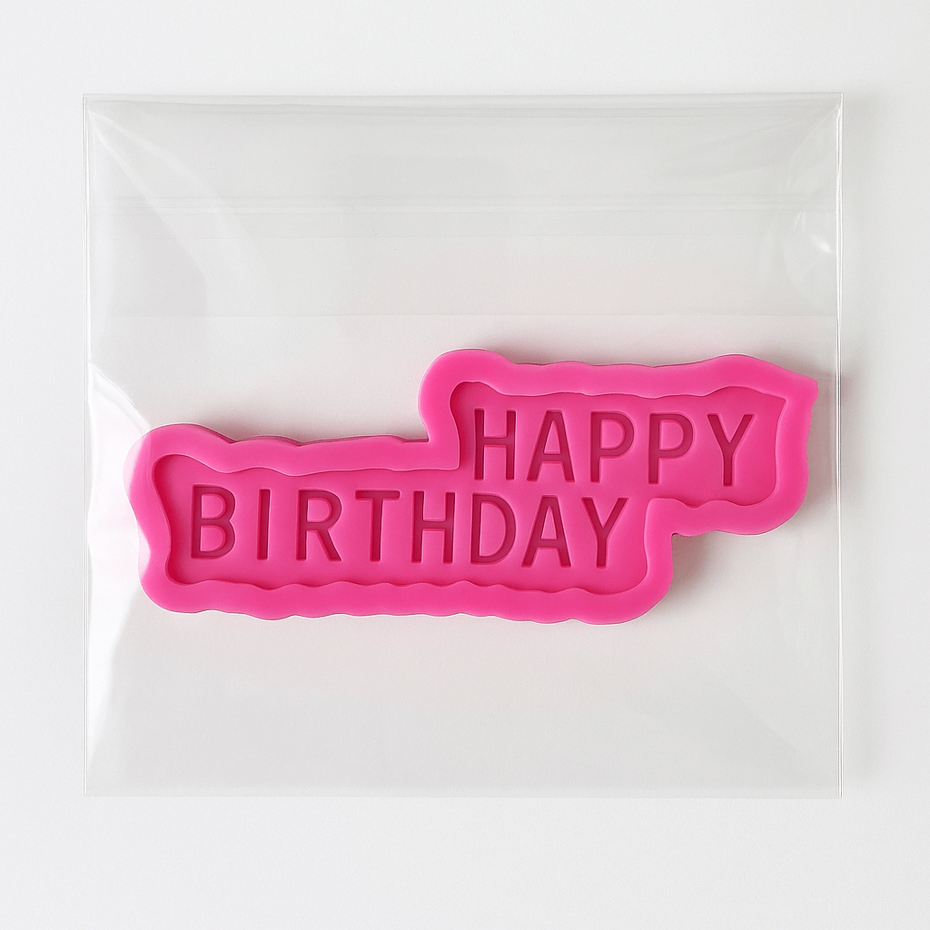 Pink 'Happy Birthday' silicone mold on a white background