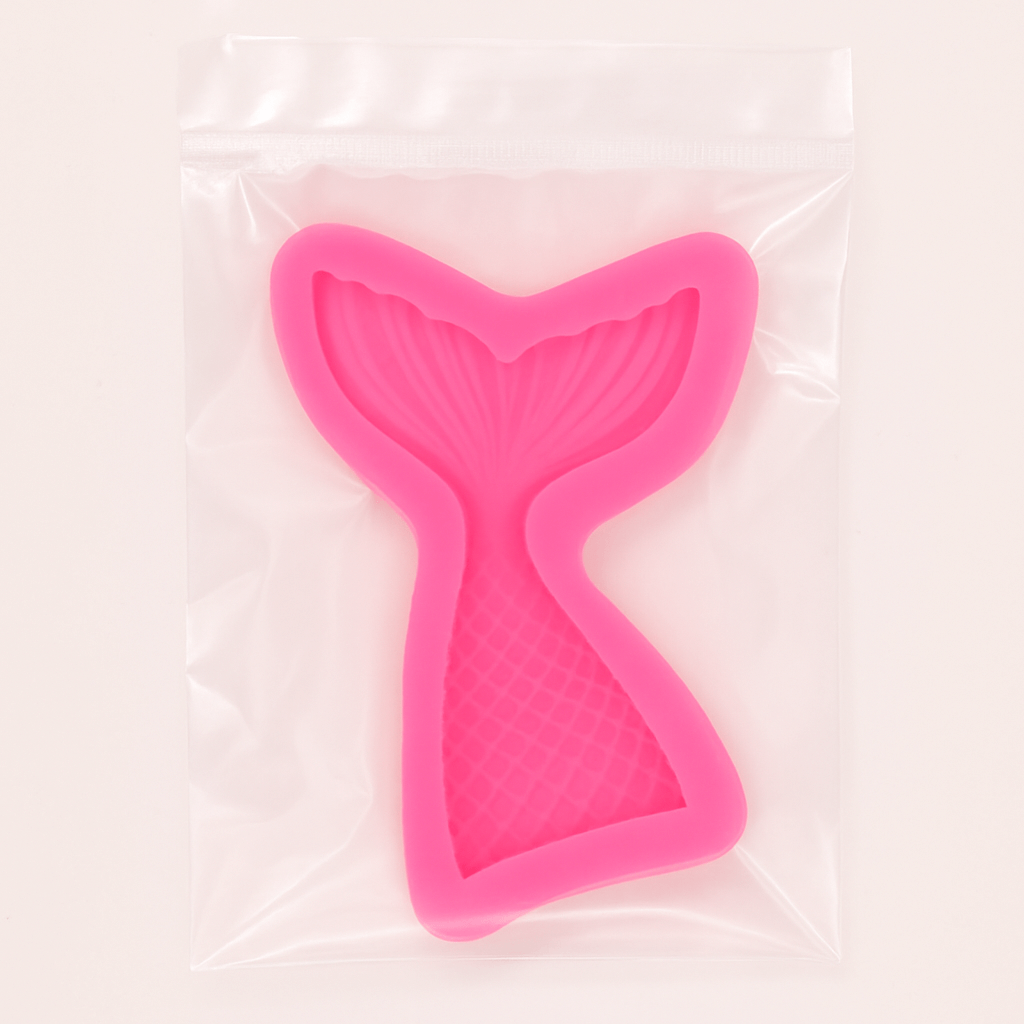 Pink mermaid tail-shaped mold in a transparent packing on a light pink background