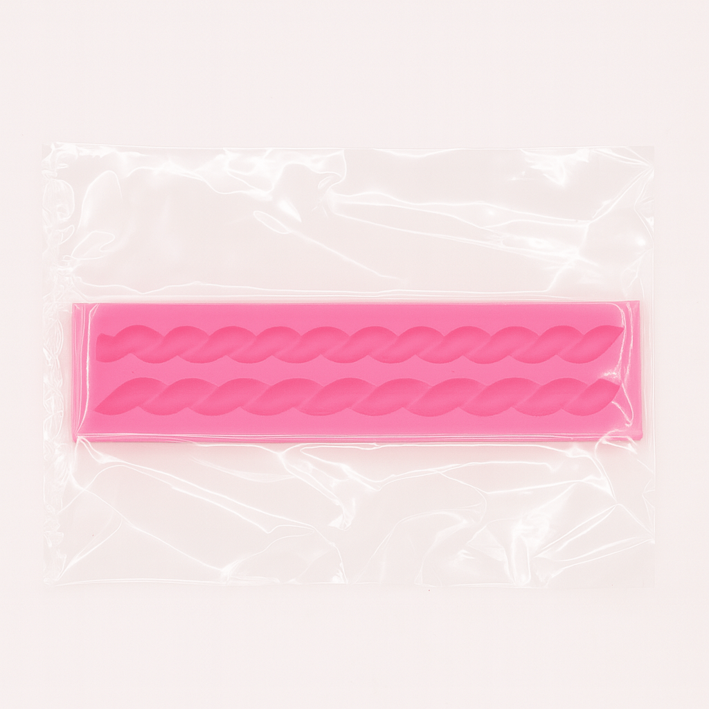 Pink silicone fondant mold with wavy patterns its packet on a clear background