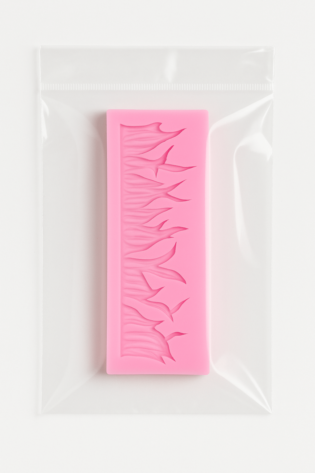 Pink silicone fondant mold with leaf pattern in a clear plastic bag on a white background