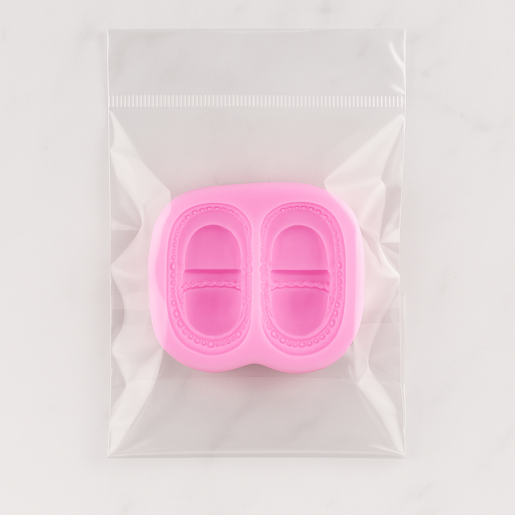Pink silicone fondant mold in a clear plastic bag on a white background