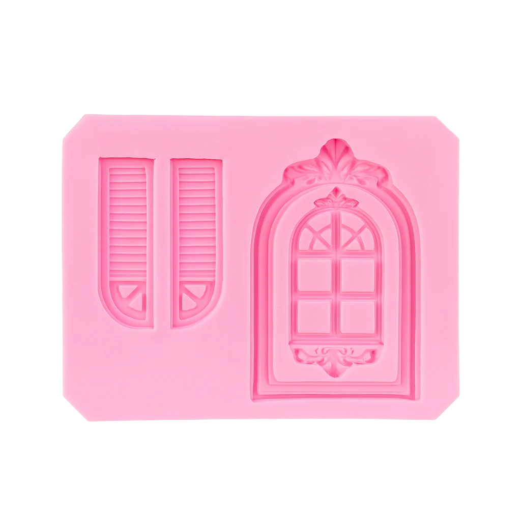 Pink silicone fondant mold with decorative door and window design on a white background
