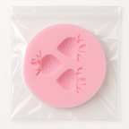 Pink silicone mold with strawberry shapes on a white background