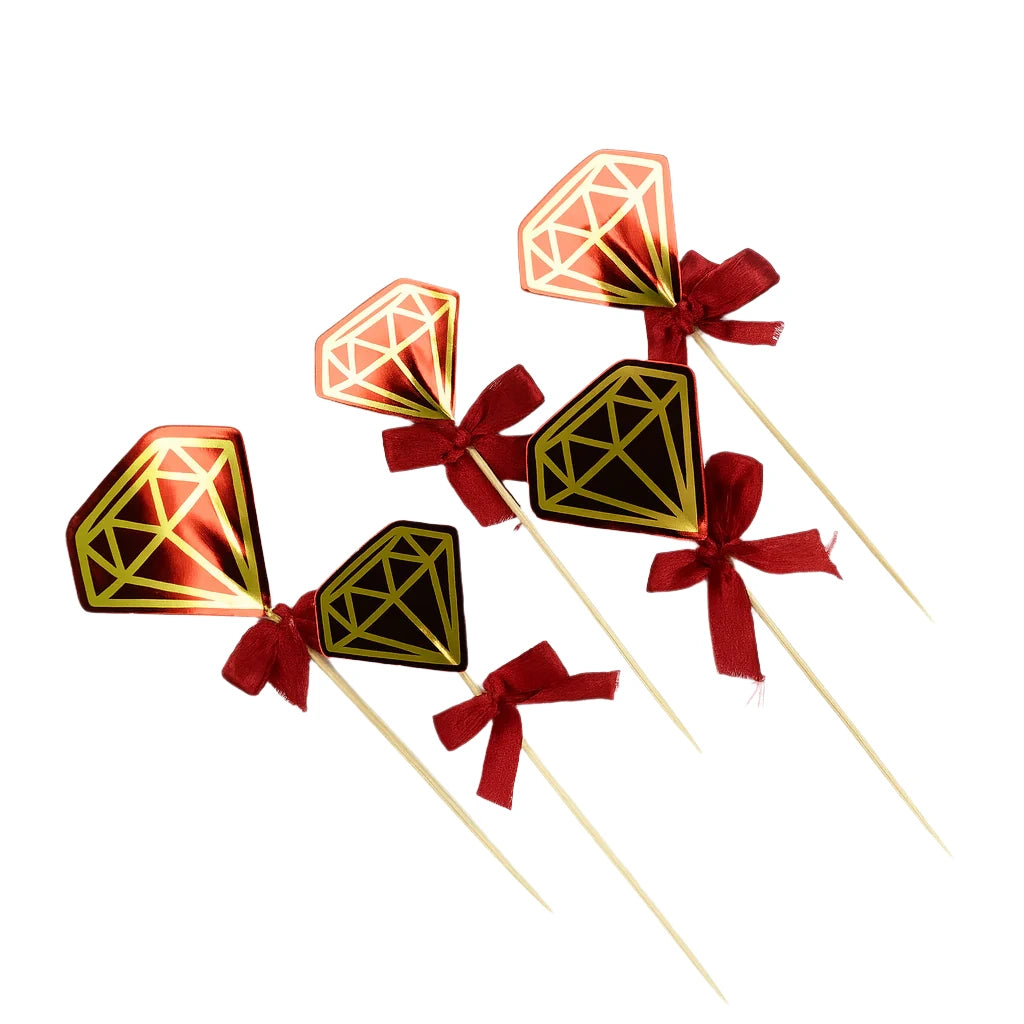 Decorative diamond cake toppers with geometric diamond designs and red ribbons on a white background