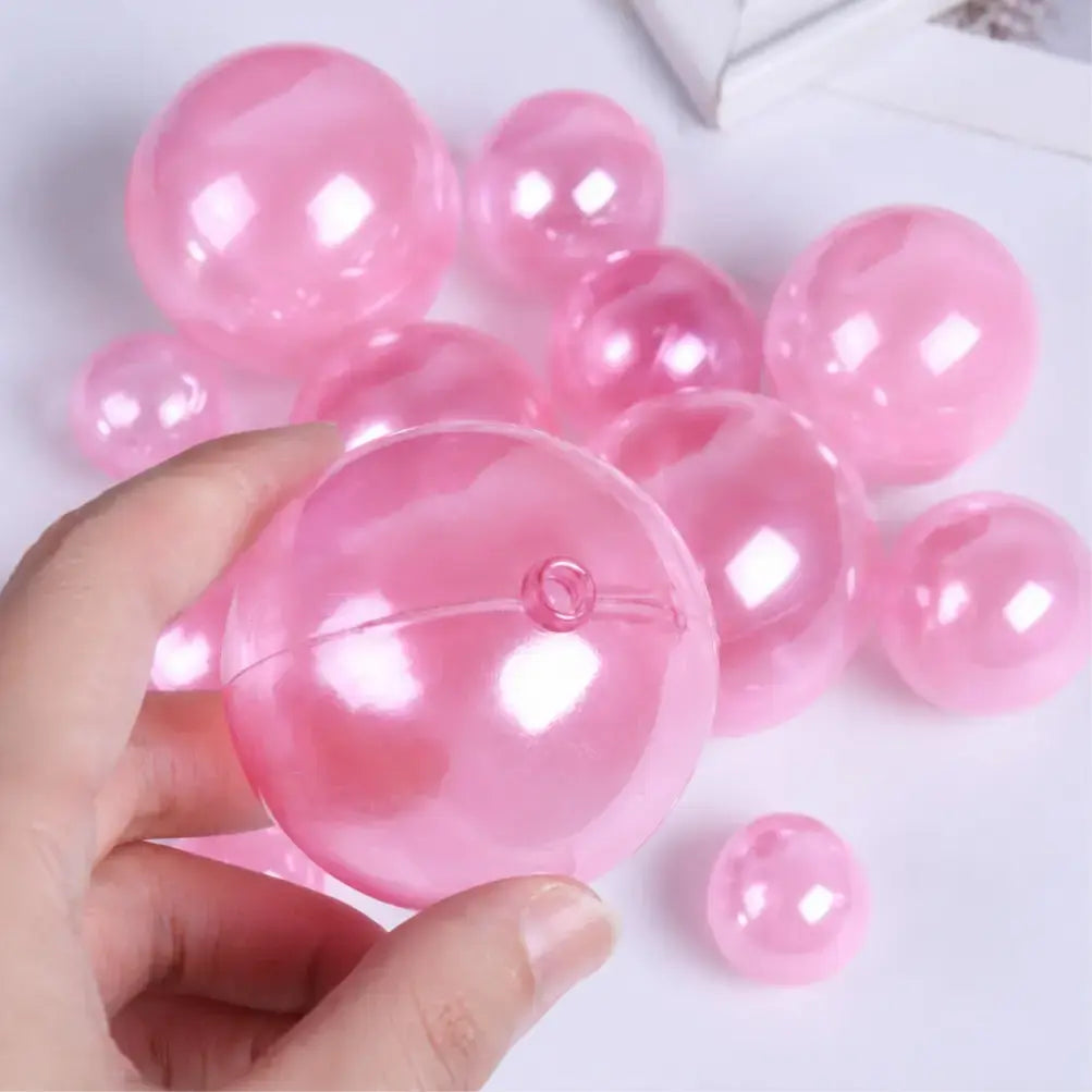 Pink Plastic Faux Ball with a hand holding one, on a light background 